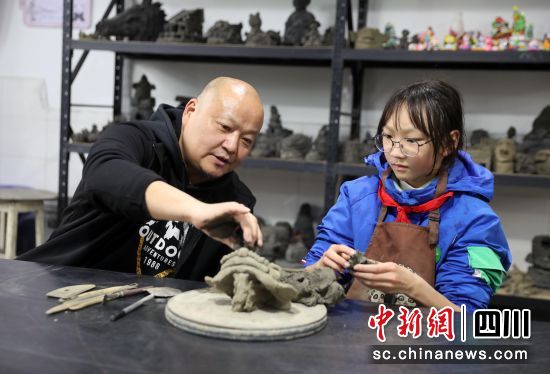近日,四川雅安,雨城區實驗小學黑砂陶藝社團指導老師蔣宏(左)正在指導學生。王磊 攝 近日,四川雅安,雨城區實驗小學黑砂陶藝社團指導老師蔣宏(左)正在指導學生。王磊 攝