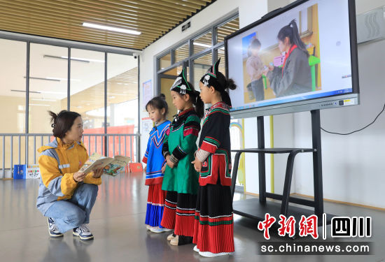 老師在指導小朋友學習普通話播報。記者 王磊 攝 老師在指導小朋友學習普通話播報。記者 王磊 攝