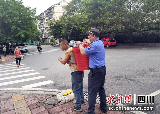 執法隊員在市容秩序日常巡邏中幫助群眾。 綿竹市融媒體中心供圖 執法隊員在市容秩序日常巡邏中幫助群眾。 綿竹市融媒體中心供圖
